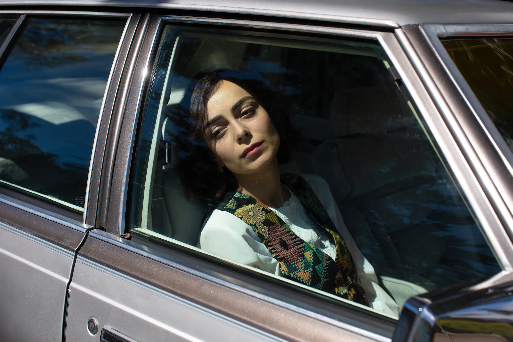 A girl sitting in the passenger seat of a car.